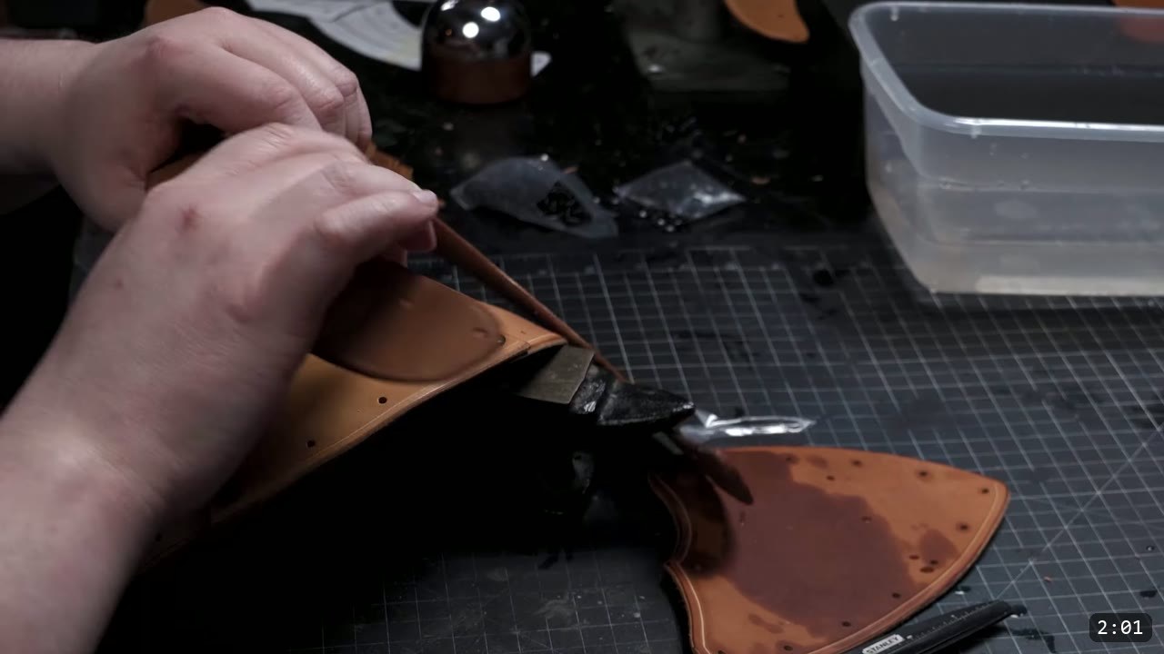 DIY Leather Pauldrons: A Beginner Build for Warrior Shoulder Armor 6 seating a rivet on the forming shoulder cap with a stylus, a round steel dome form sitting on the bench nearby